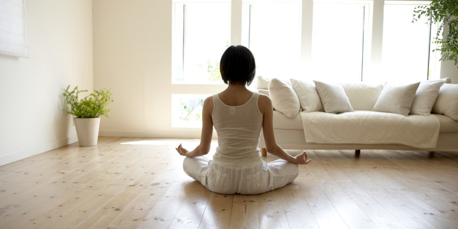 Young woman performing yoga pose in living room