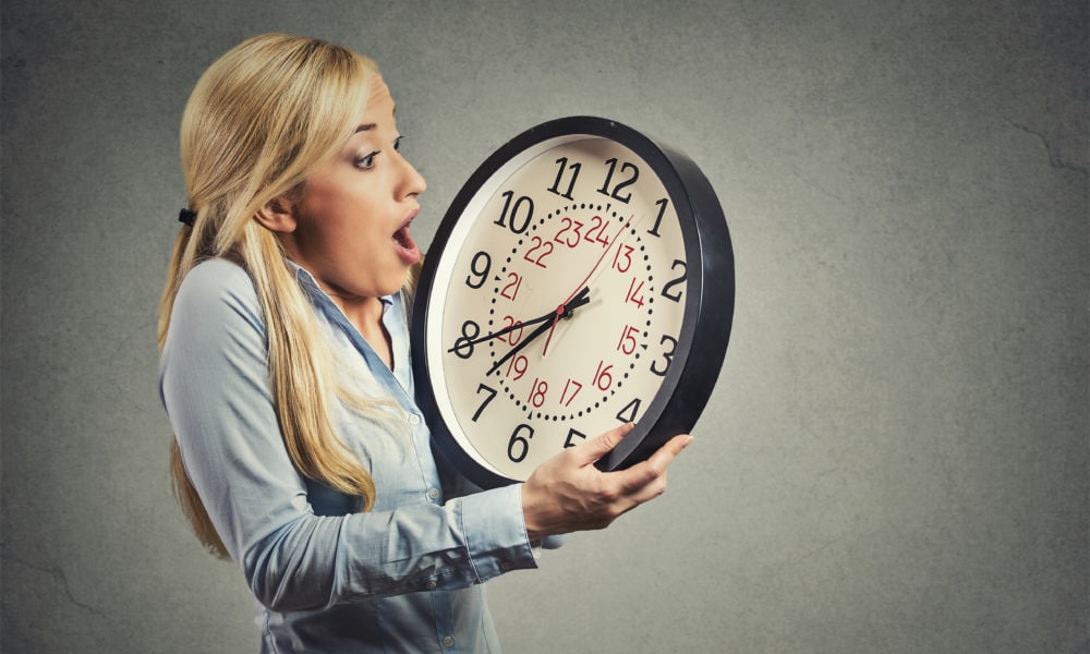 Woman holding clock looking anxiously, running out of time