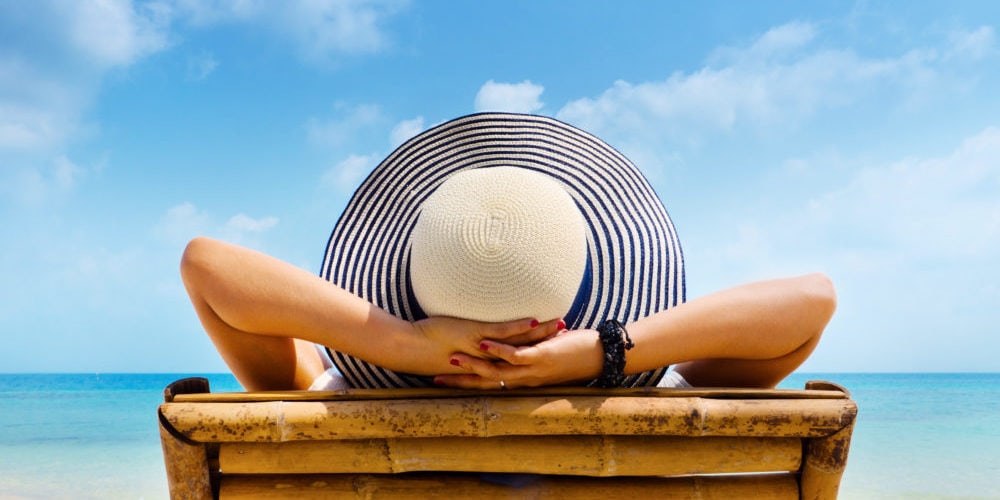 Woman in hat relaxing on beach